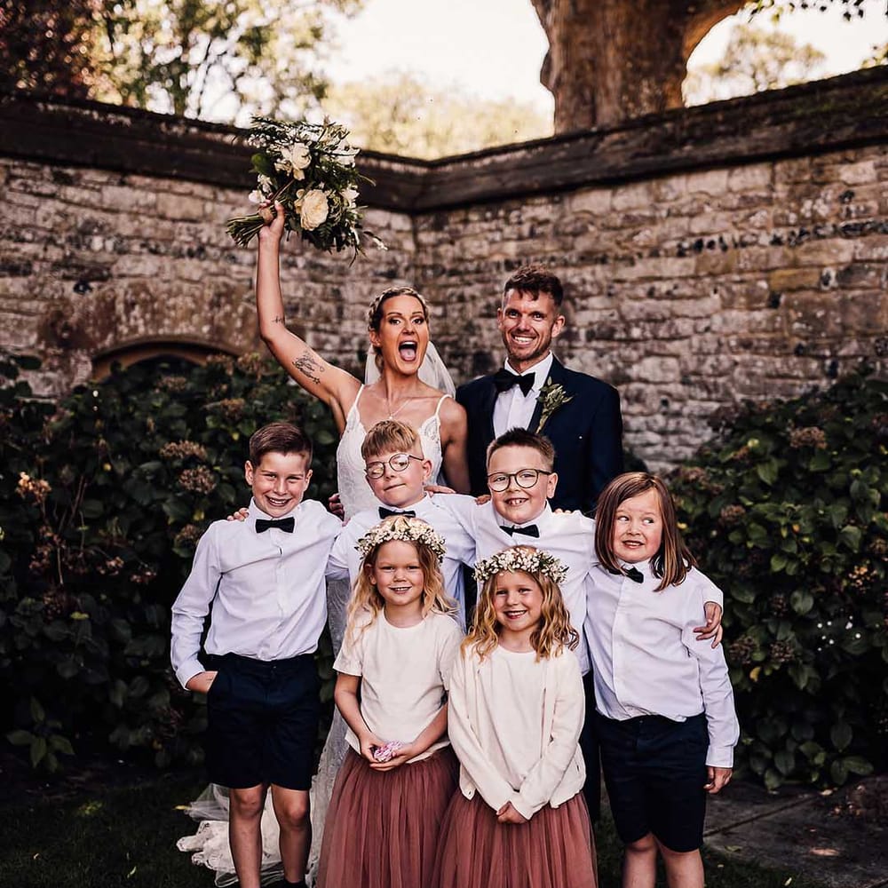 Bride and groom pose with their son, daughter, niece and nephews 