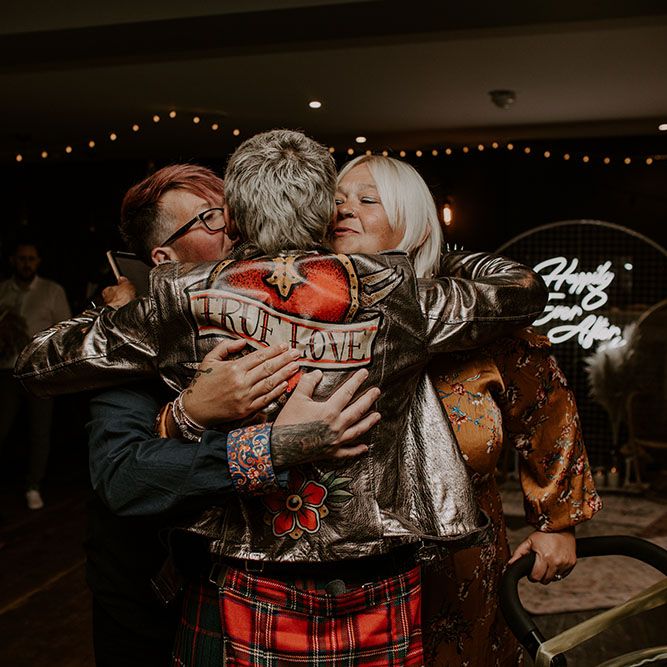 Groom wears True Love gold leather jacket and hugs wedding guests 
