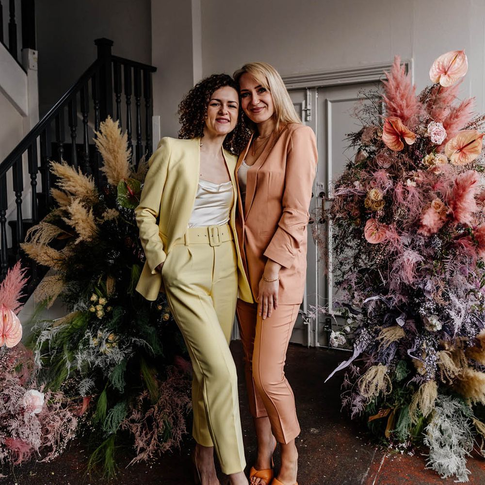 yellow and peach bridesmaids suits at modern and stylish London wedding with pastel coloured column floral arrangements 