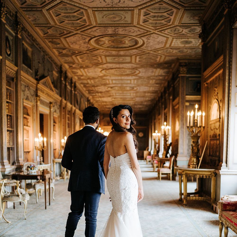 Bride wears fitted lace mermaid wedding dress and walks alongside her groom 