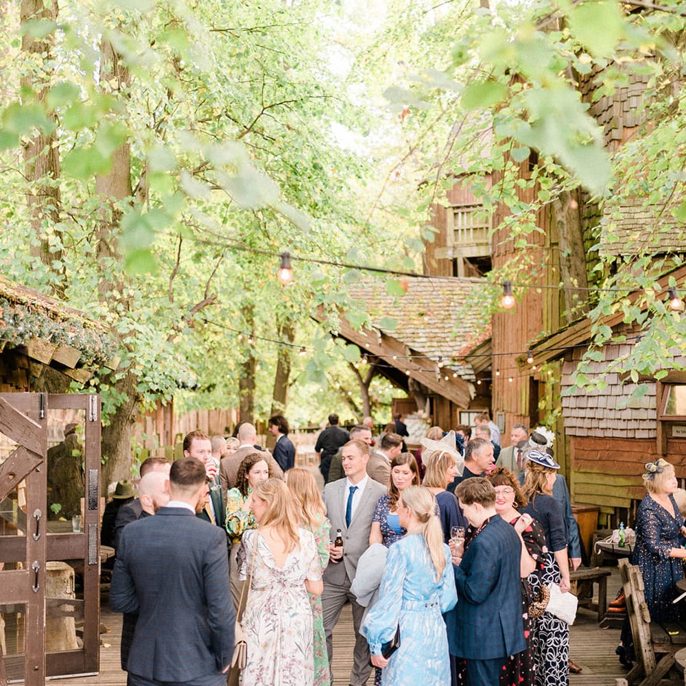Wedding guests gather outdoors at the Alnwick Garden Treehouse wedding venue 