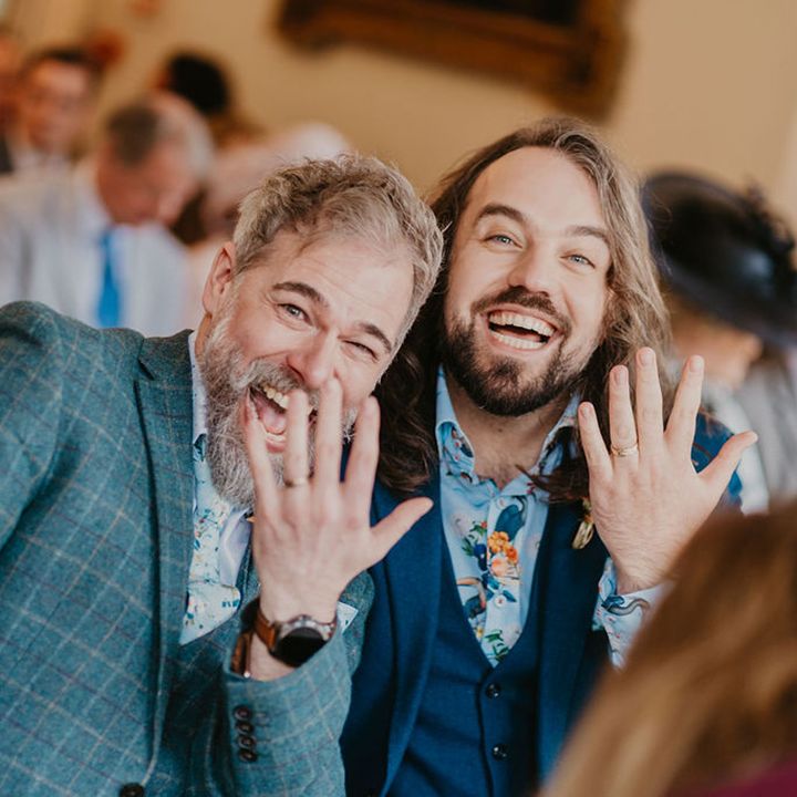 Grooms show off their wedding bands after ceremony at the Cambridge Cottage in Kew Gardens 