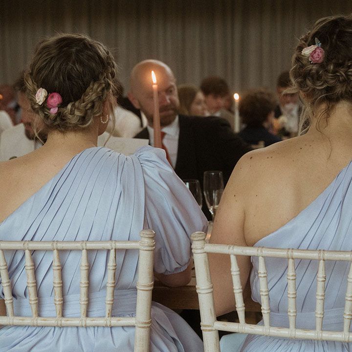Bridesmaids in one shoulder blue bridesmaid dresses sitting for the wedding breakfast 
