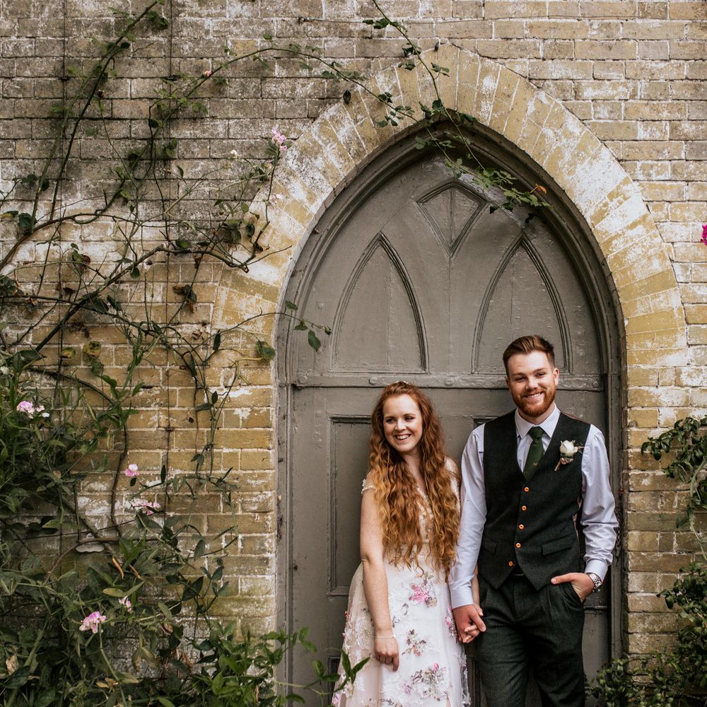 Bride & groom in front of door with foliage 