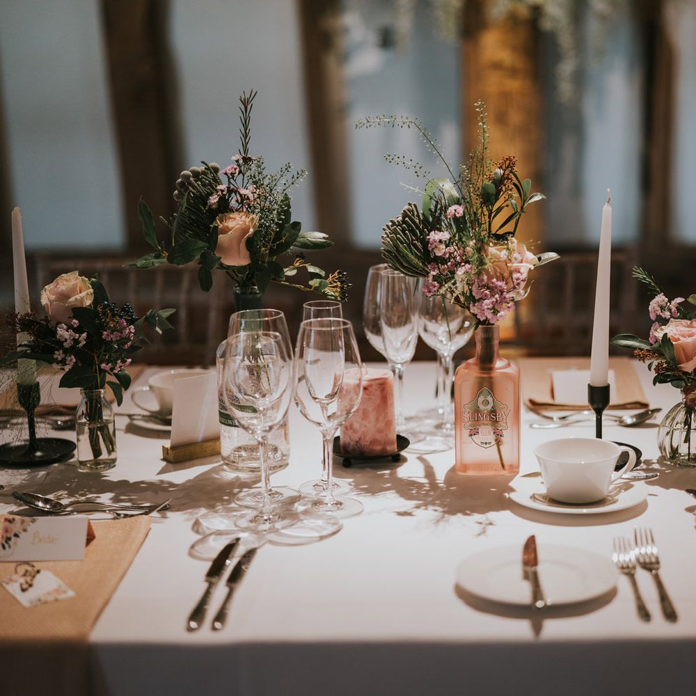 Table decor featuring gin bottles with floral decor