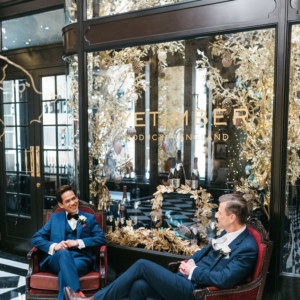 Grooms sit together before wedding ceremony