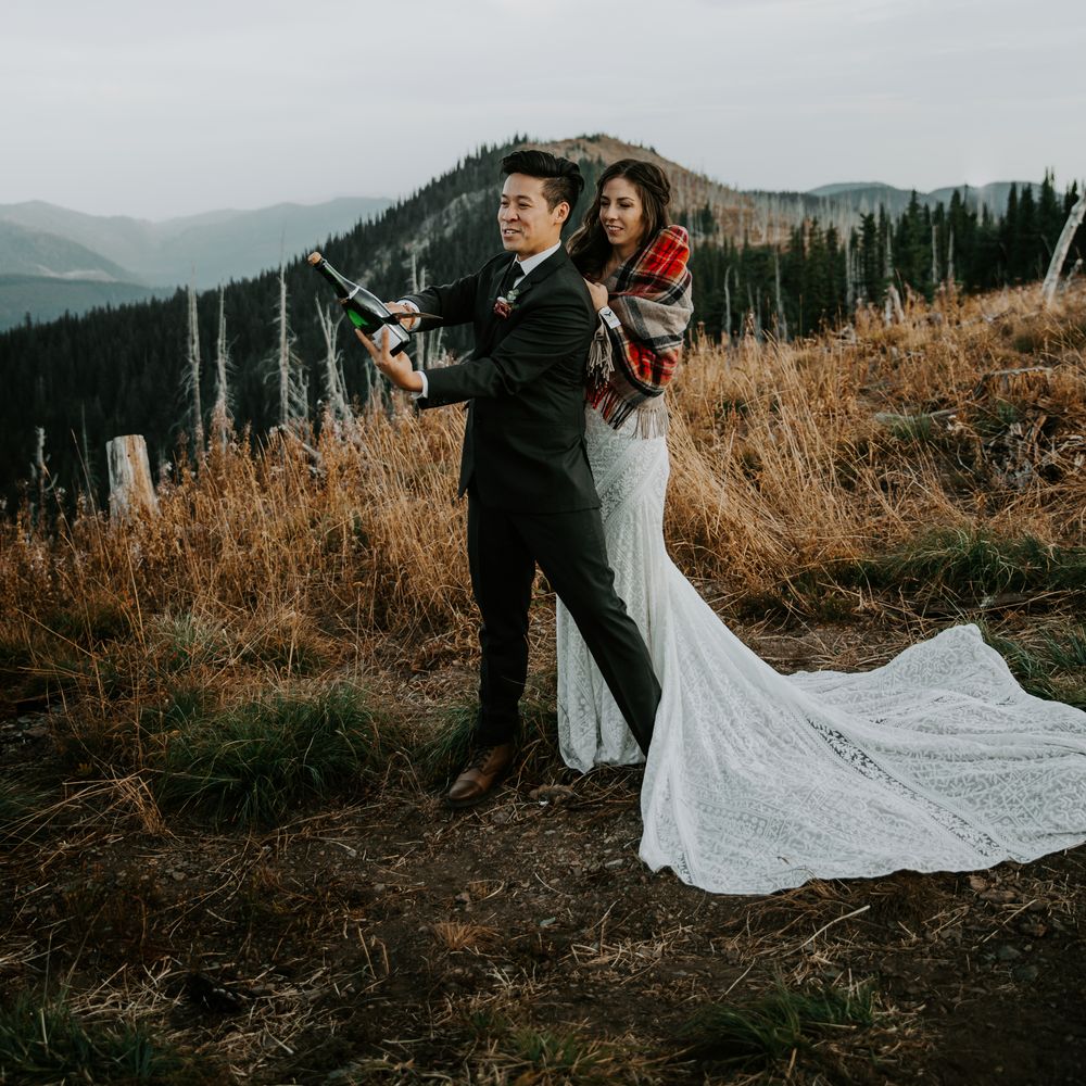 Bride & groom stands atop mountains and embrace during ceremony