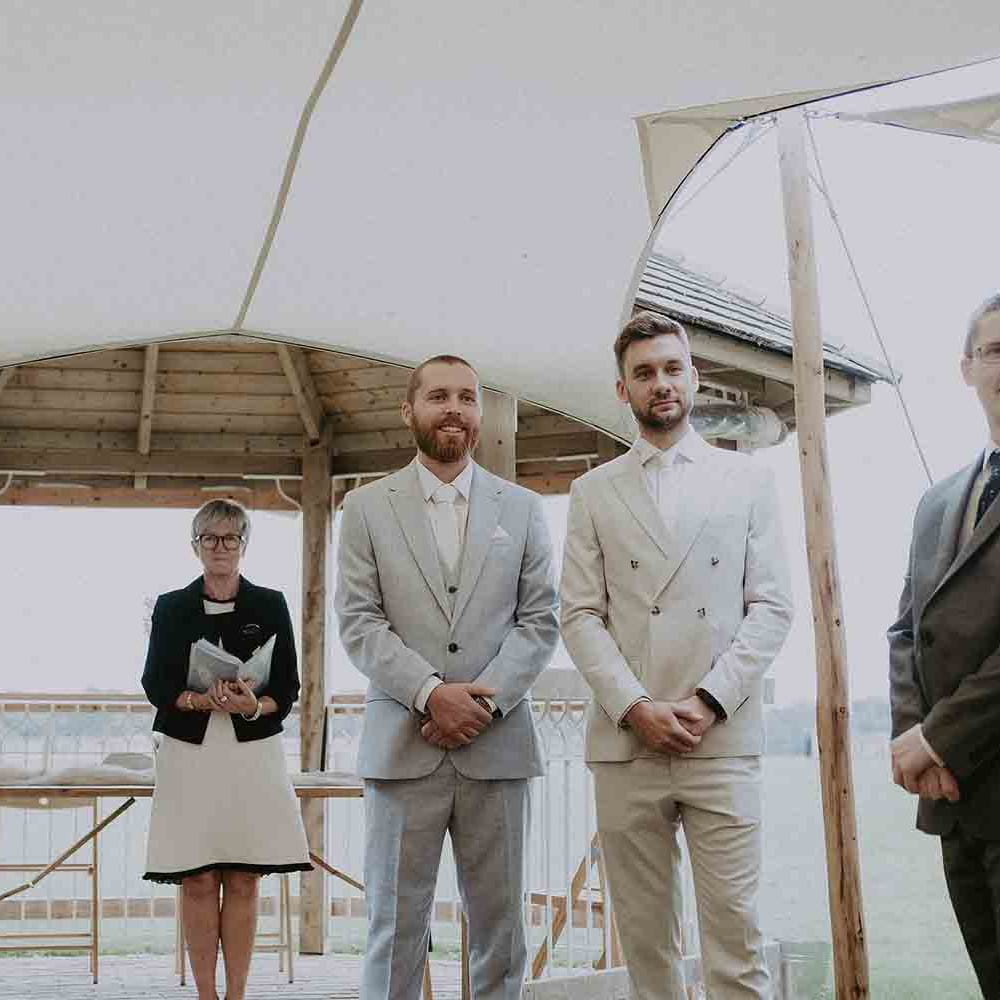 Groom watches bride walk down the aisle at outdoor ceremony