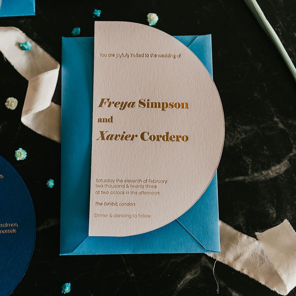 Stylish wedding invitation with gold foil font and teal envelope 