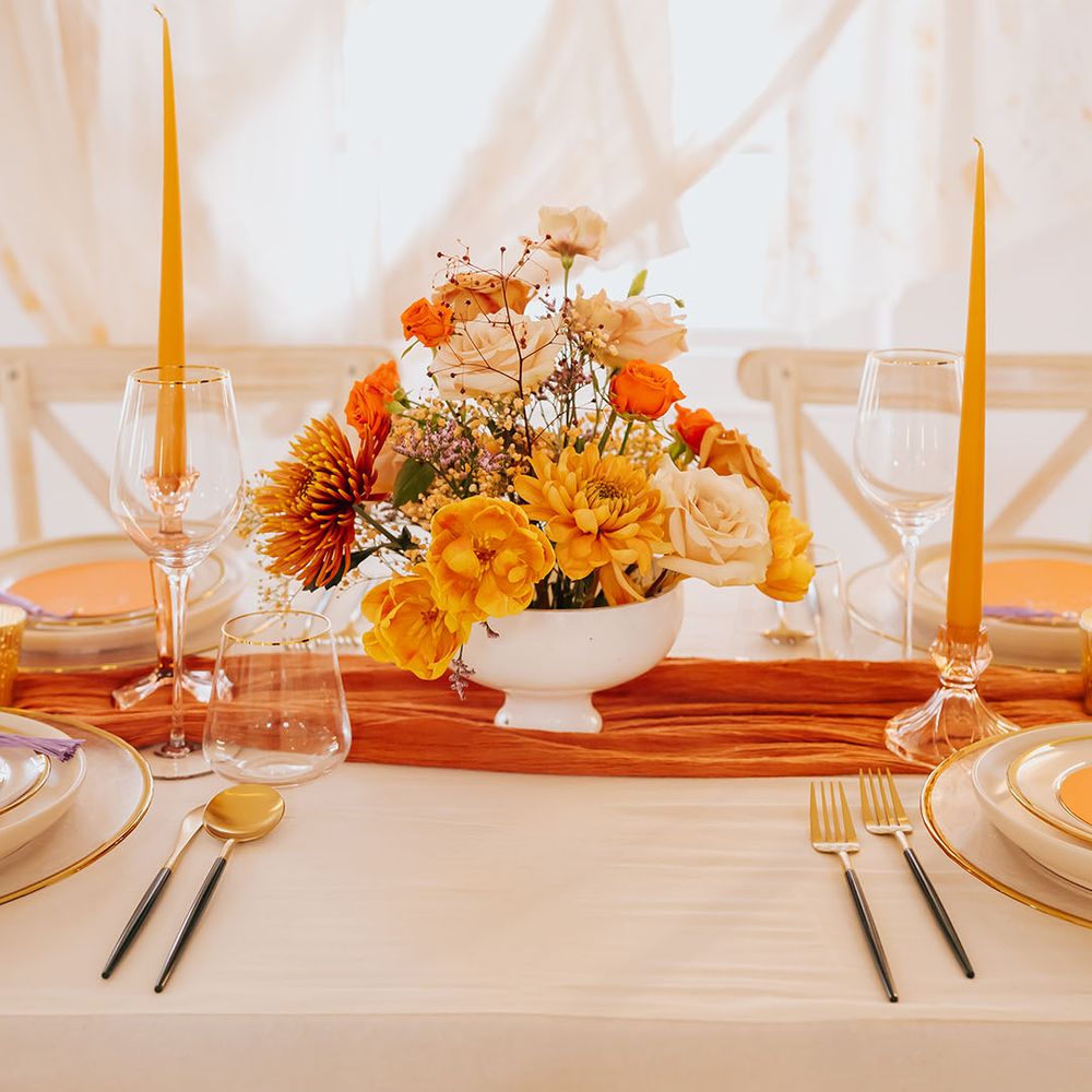 orange and yellow golden wedding flower arrangement and taper candles wedding table decor 