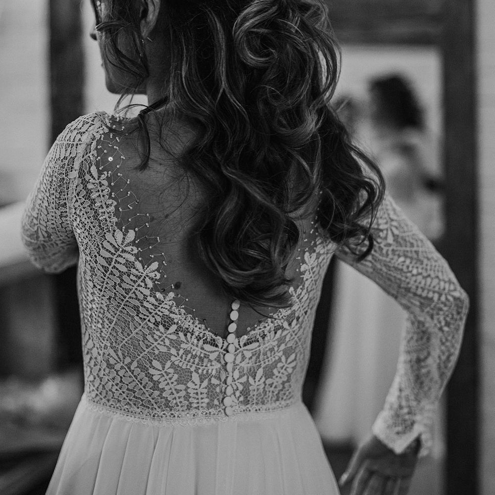 Illusion back wedding dress with patterned lace, long sleeves and button detail