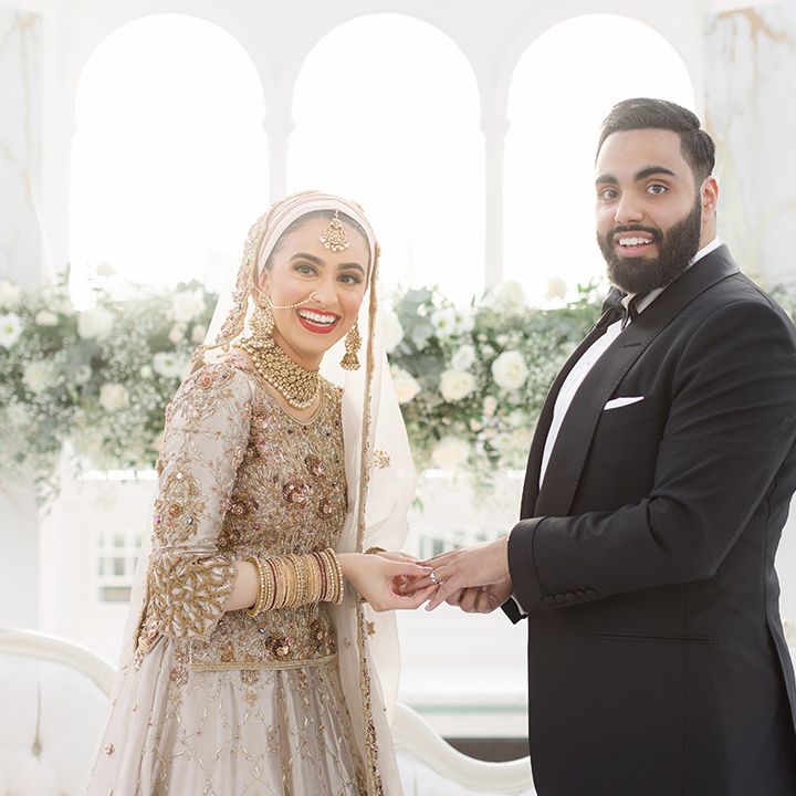 Bride wears traditional saree in gold and silver as she holds her grooms hands who wears black tie 