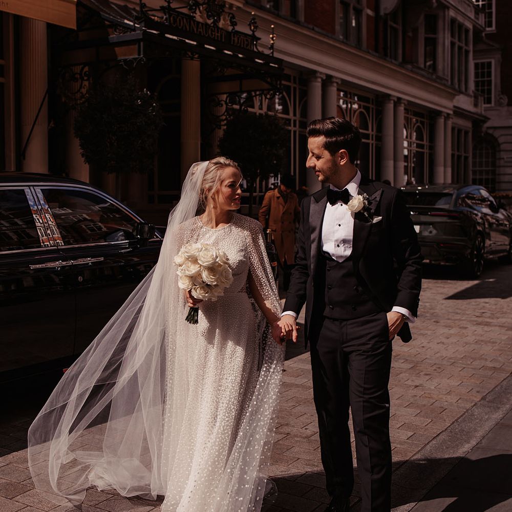 Bride in sparkly wedding dress walks with groom in black tie around London for their city wedding 