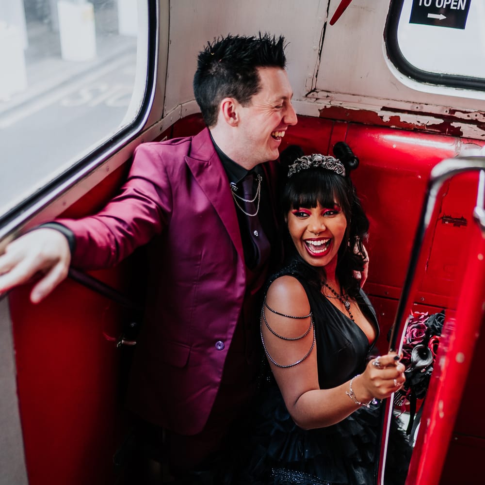 Bride & groom walk down staircase in retro London bus for gothic city wedding 