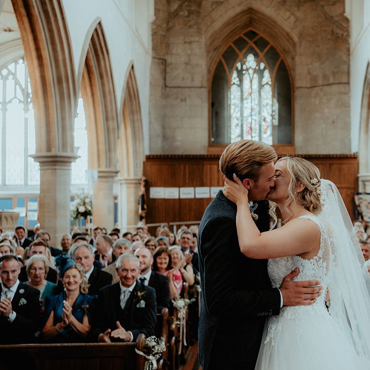 Brie and groom share their first kiss as a married couple with the wedding guests watching on in happiness 