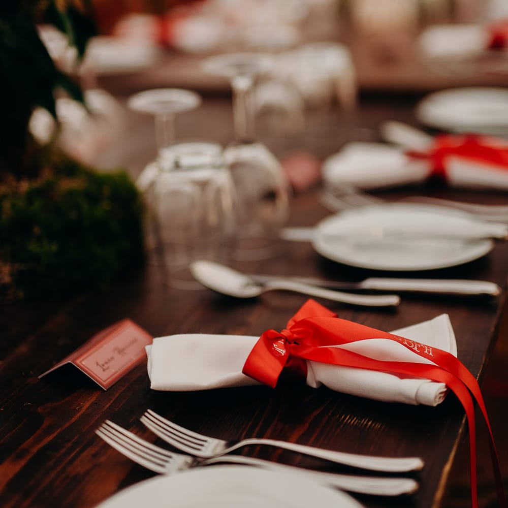 Christmas themed wedding tablescape with red ribbon napkin accessory