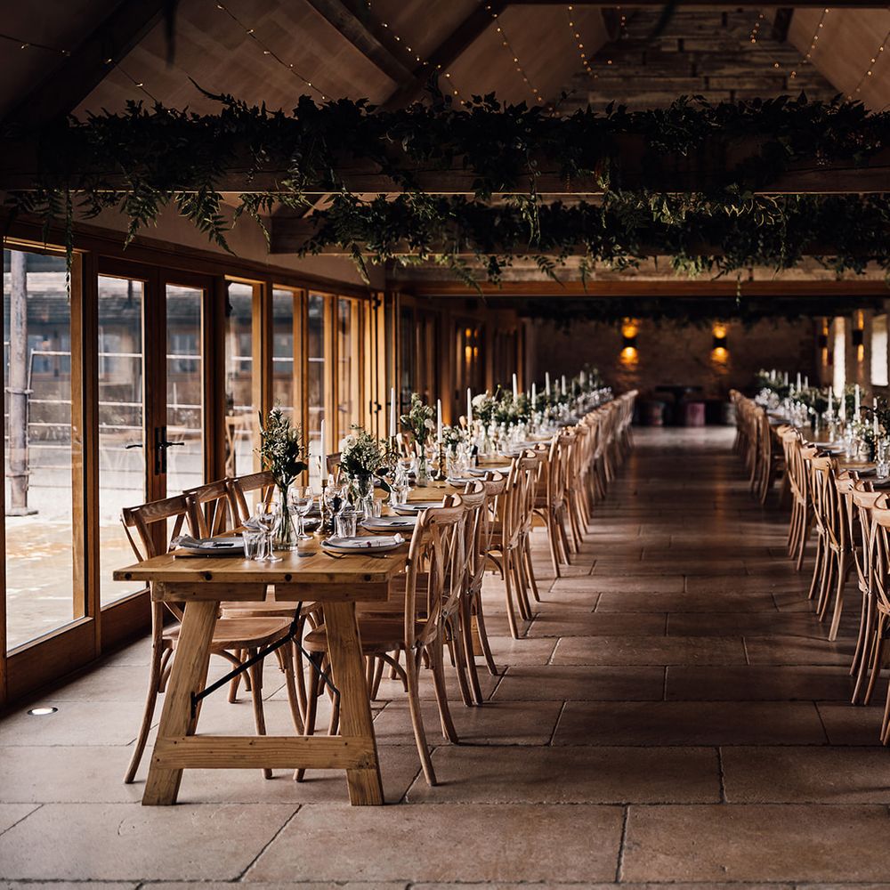 Old Gore Barn rustic wedding venue with green foliage and tables made with a classic green and white wedding tablescape 