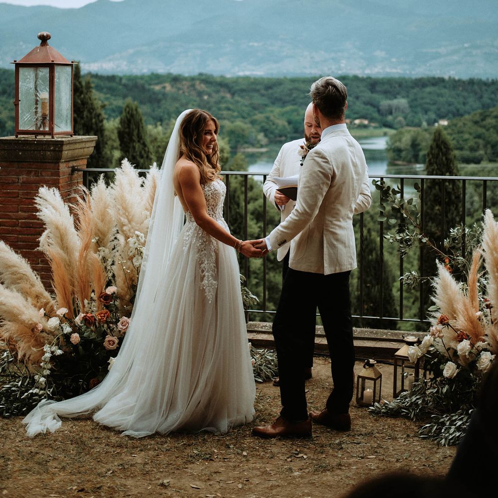 bride and groom at altar decorated with pampas grass at Italian destination wedding in Tuscany