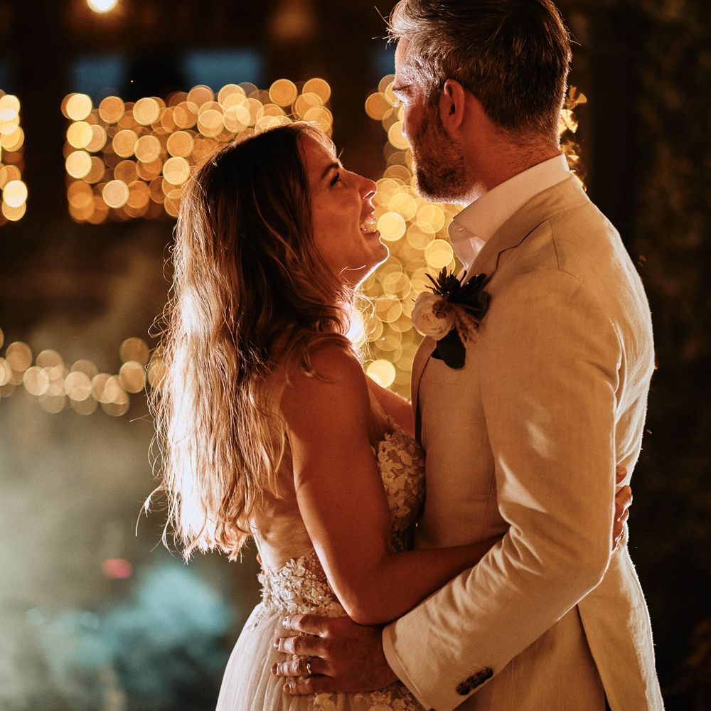 Bride and groom share first dance under festoon lighting at Italian villa destination wedding