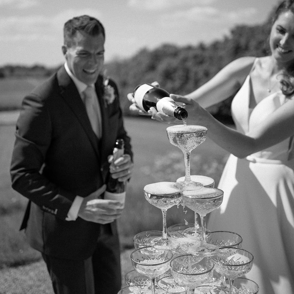 The bride and groom with their stunning wedding champagne tower 