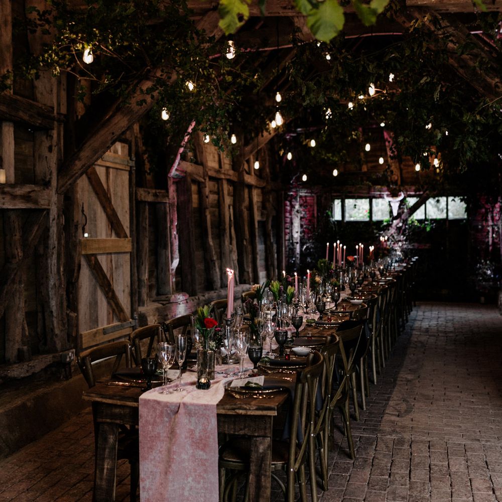High Billinghurst Farm barn intimate wedding reception with lights and candle decor