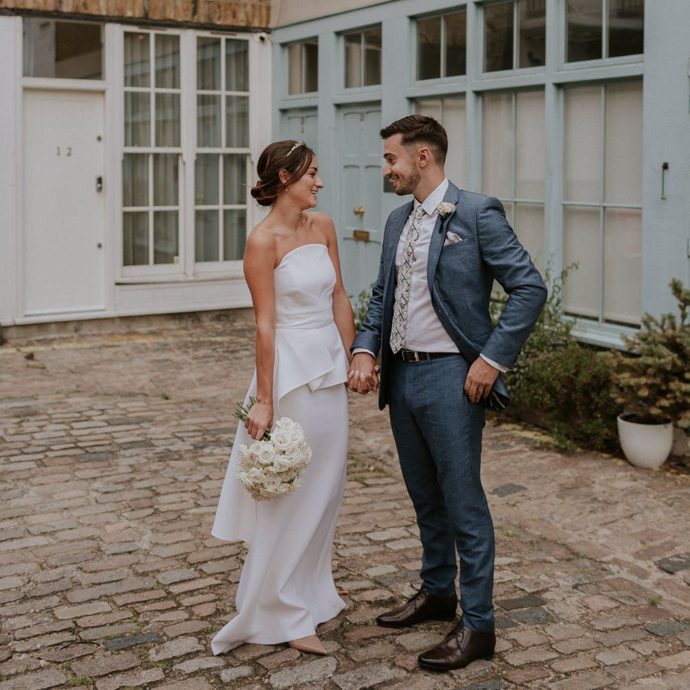 Bride in strapless Roland Mouret wedding dress and groom in blue suit