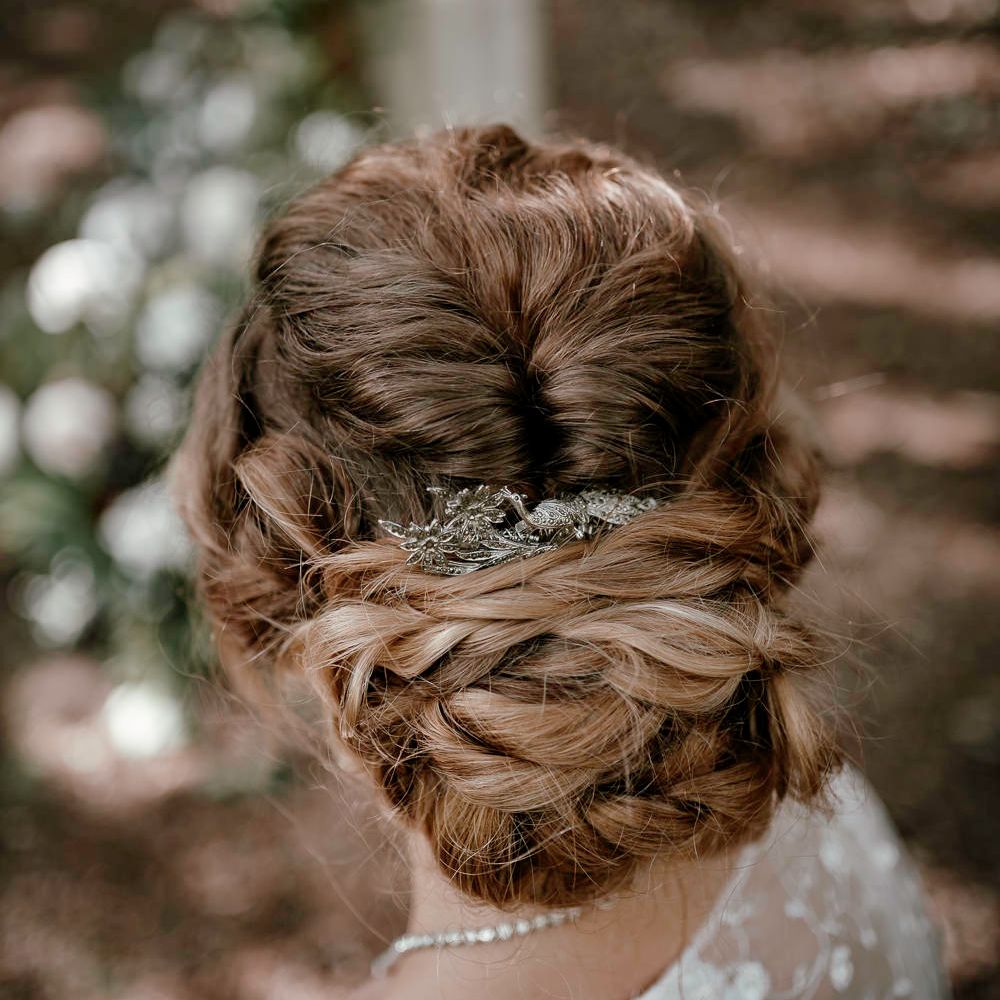 Pinned updo with peacock hair accessory 