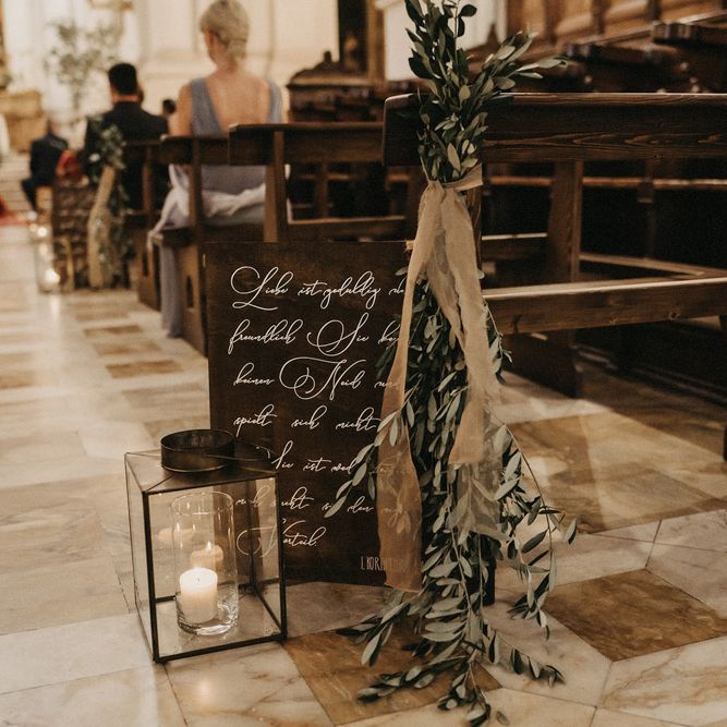 Olive bouquet details at the end of a church pew