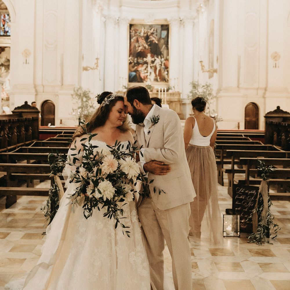 Just married at a church in Tuscany, holding an olive bouquet