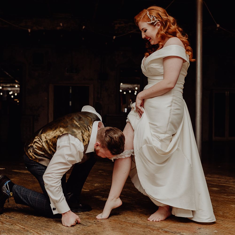 Groom removing his brides wedding garter 
