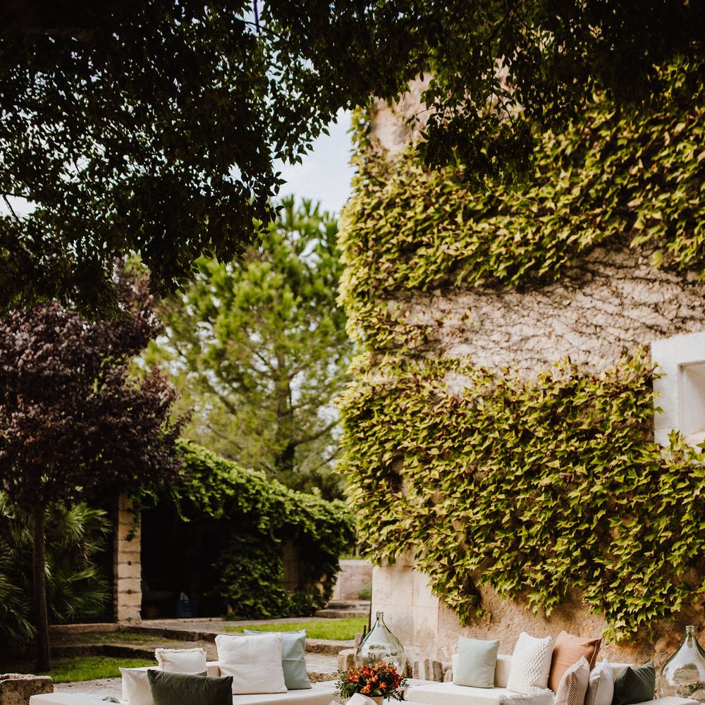 Outdoor table and sofa surrounded by green foliage