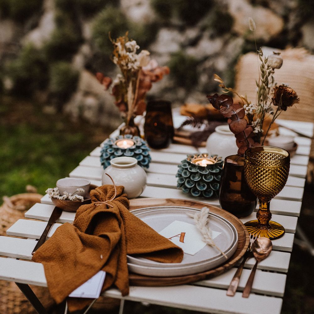 Outdoor table setting with white plates and wooden placemats