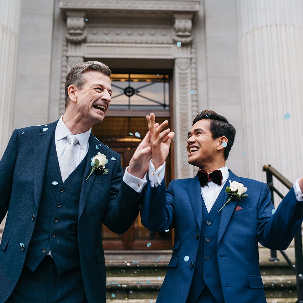Grooms laugh and celebrate after wedding ceremony