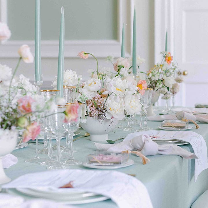 elegant wedding table decor with pale green tablecloth and summer flower centrepieces including roses and peonies