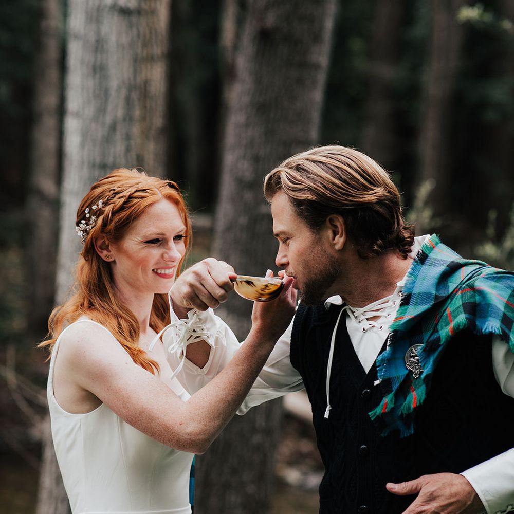 Scottish highland wedding with bride and groom drinking from the quaich cup