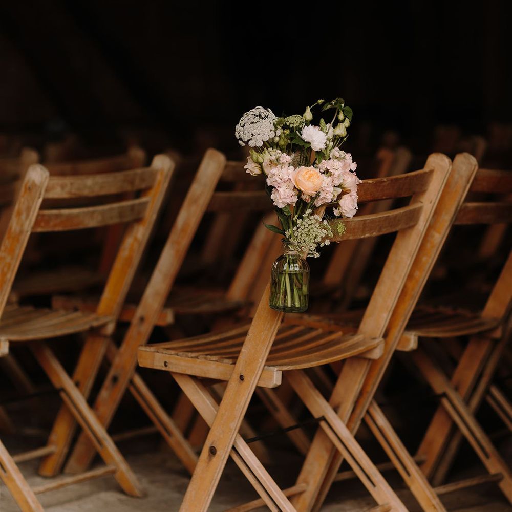 Wooden wedding chairs with flower decor for ceremony