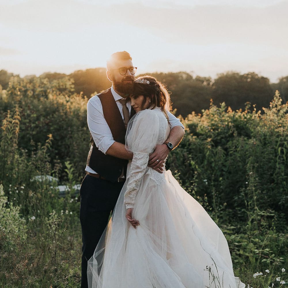 Newlyweds at their LGBTQI+ wedding embrace amid greenery and foliage