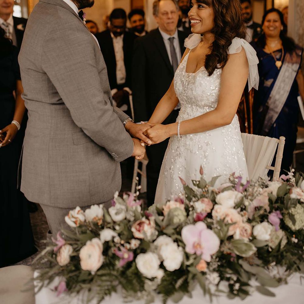 Bride and groom at the alter, holding hands and smiling