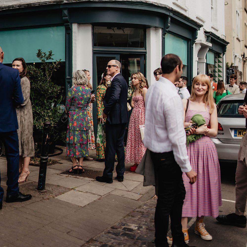 Wedding guests gather outdoors before wedding reception at restaurant in Bristol 