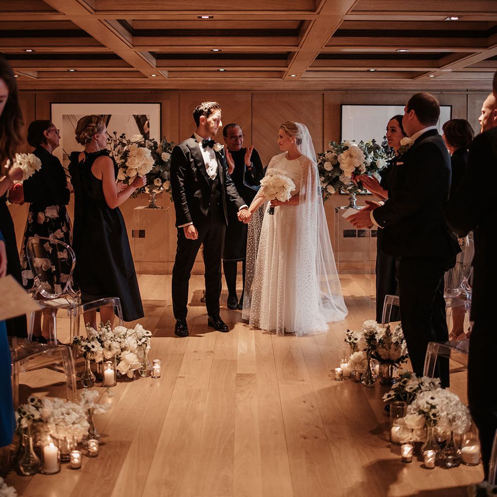 Bride and groom hold hands as they walk back down the aisle as husband and wife 