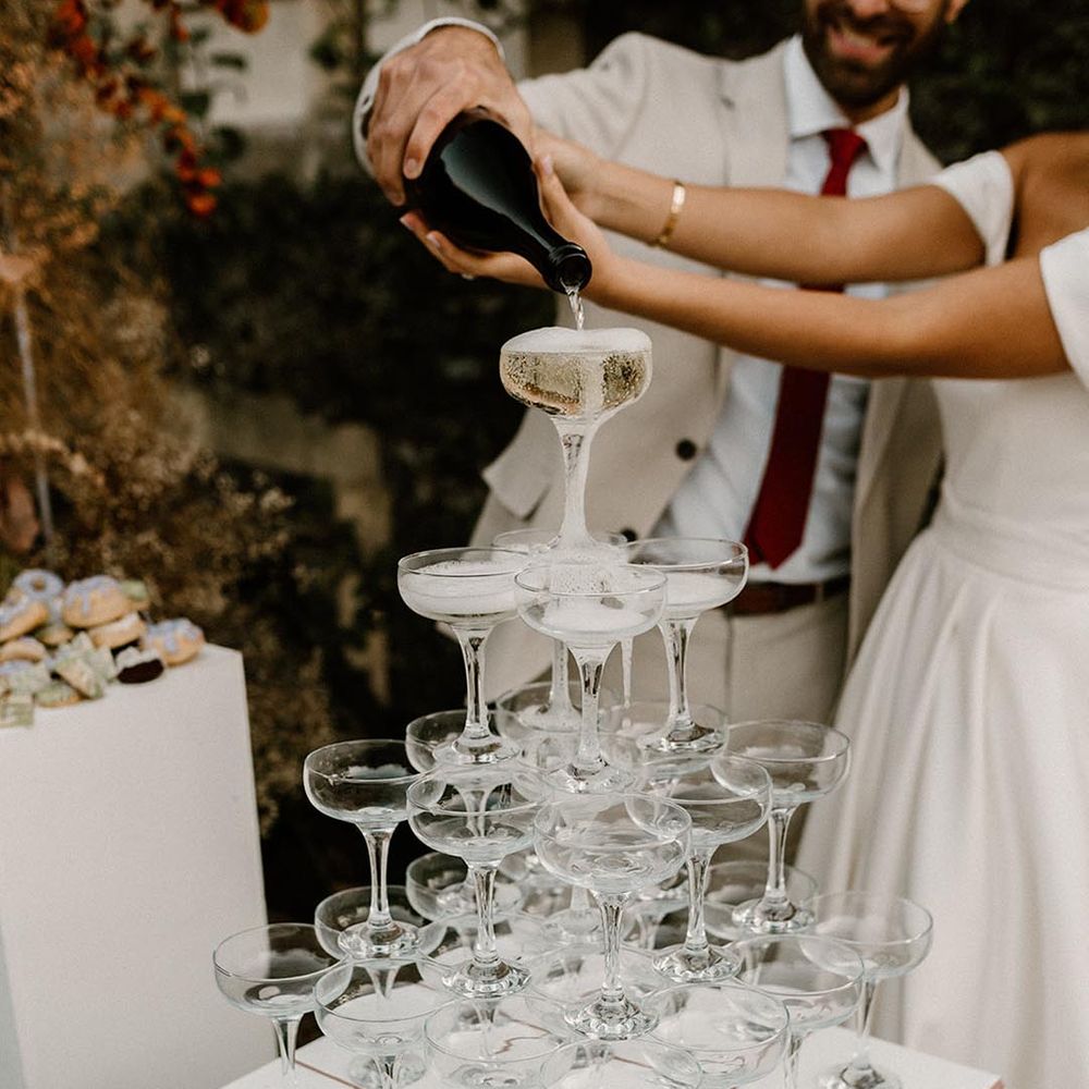 Champagne tower with the bride and groom pouring the champagne