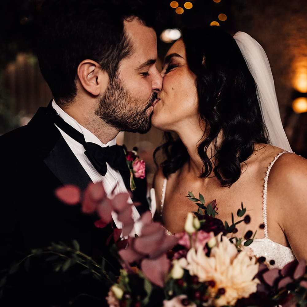 The happy couple share a kiss together 