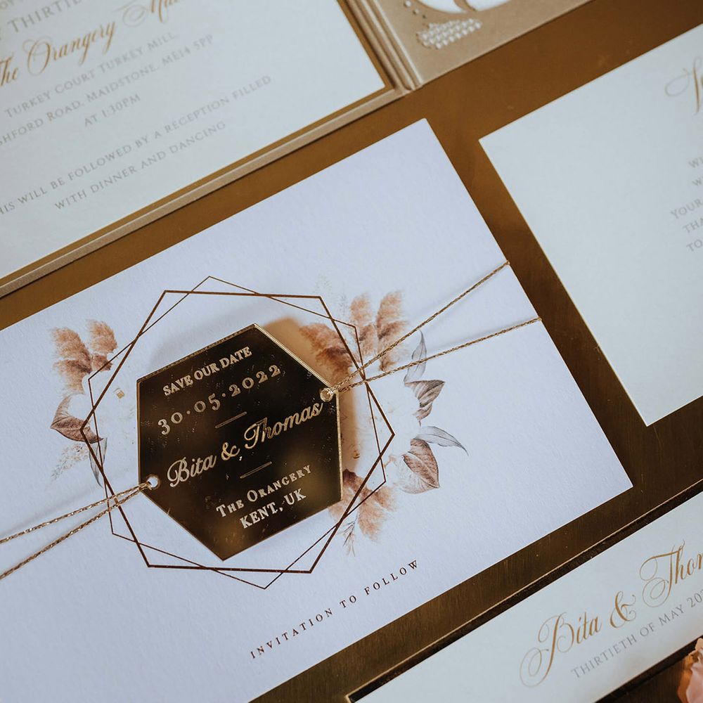 Classic and elegant white and gold wedding stationery include the save the date 