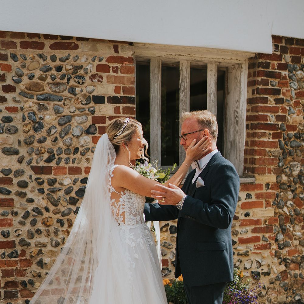 Father of the bride in navy suit and light grey bow tie sees the bride in her Dando London wedding dress for the first time 