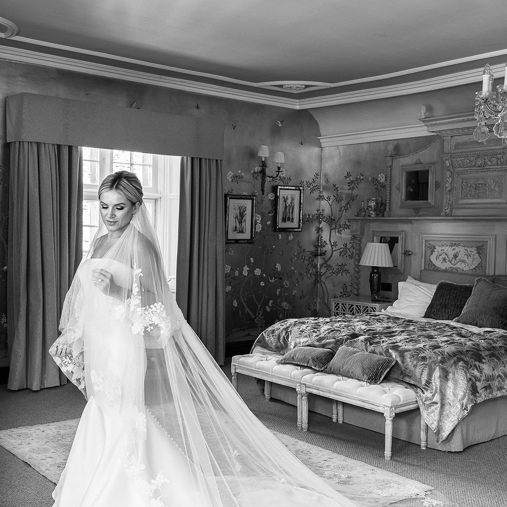 Bride in the bridal suite at The Manor House, Castle Combe for the classic wedding wearing a mermaid wedding dress and statement veil 