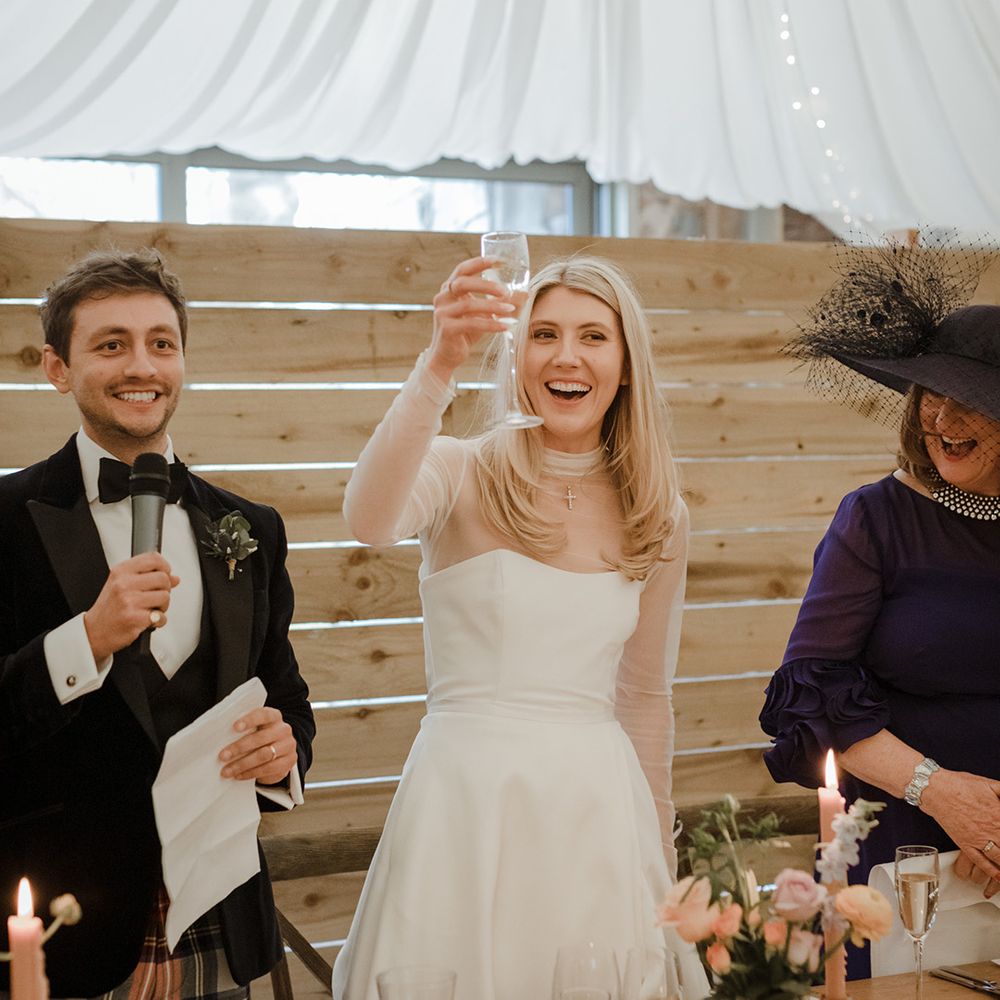 The bride and groom make a toast during the speeches on their wedding day 