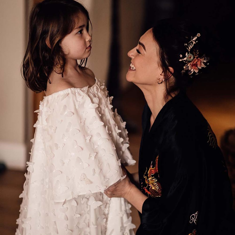 Flower girl in an off the shoulder white 3D butterfly dress 