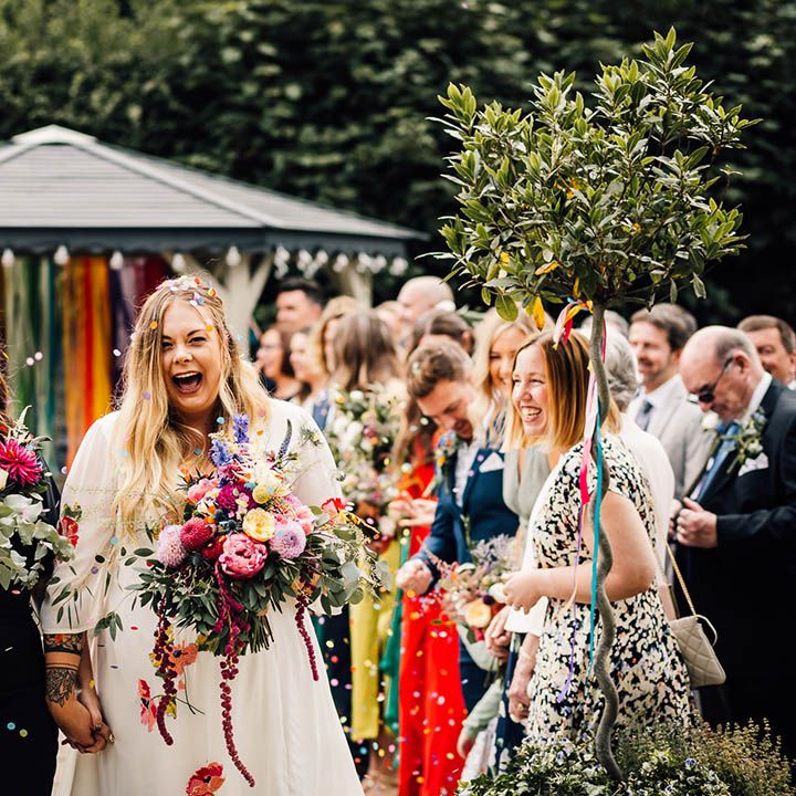 Lesbian wedding with two brides leaving the ceremony as a married couple as confetti is thrown 