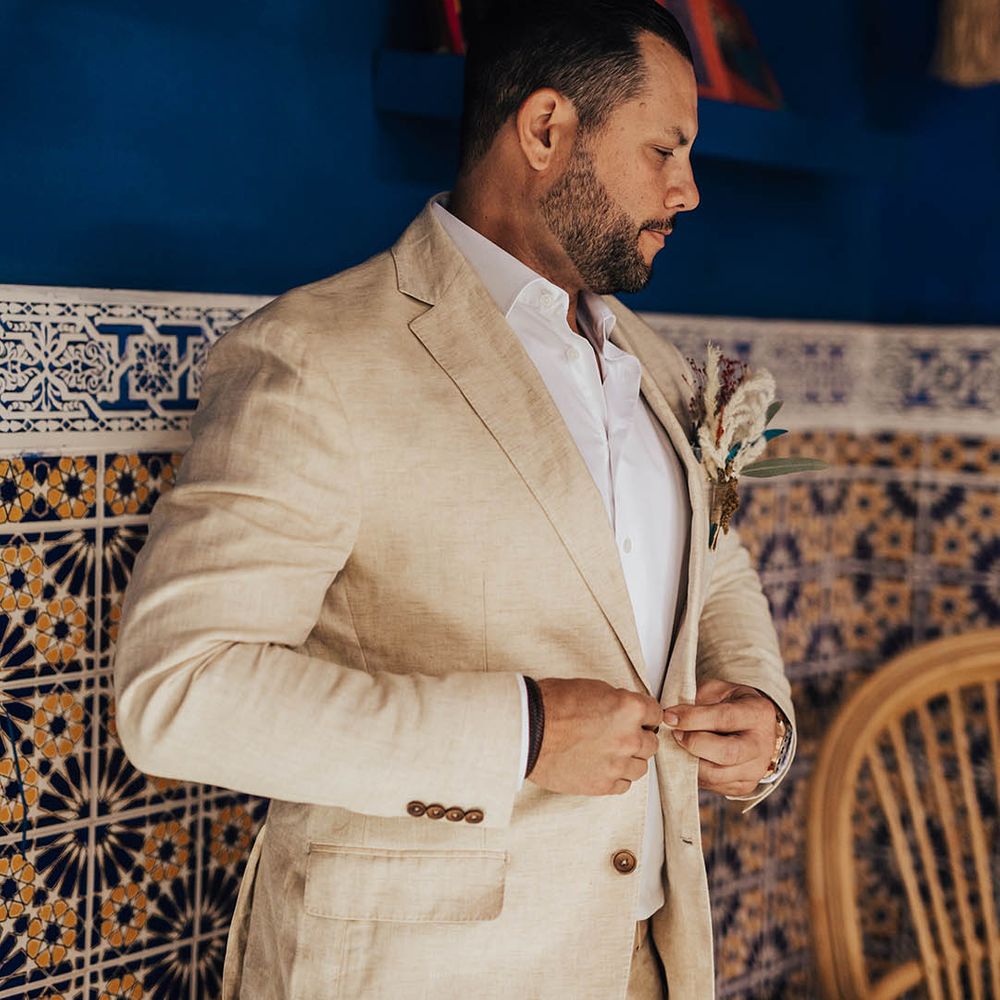 Groom in beige suit gets ready for the wedding 