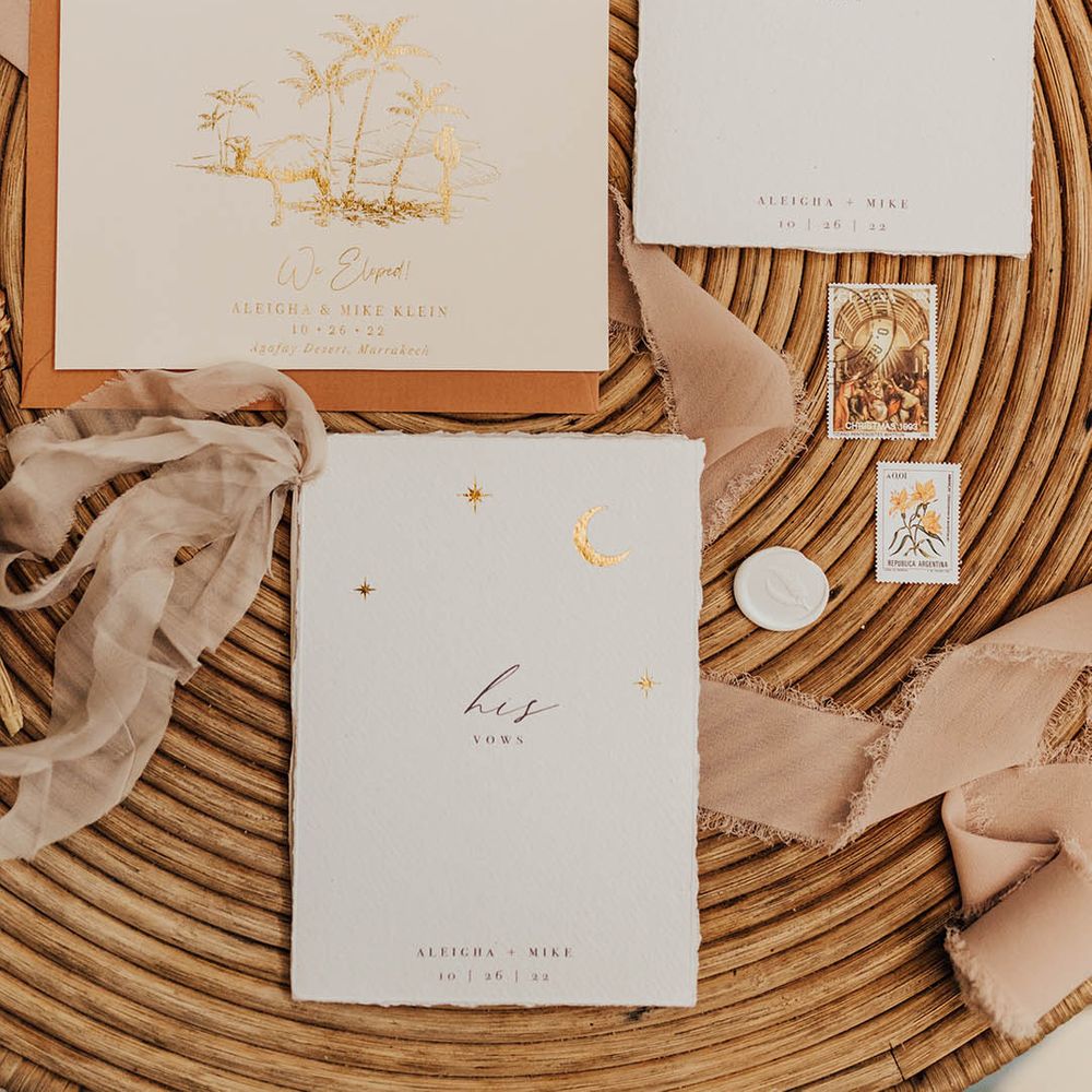 Wedding stationery flatlay with vow booklets and gold moon design 